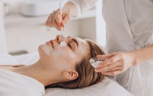 Close-up of a chemical peel being applied to a woman's face by a skincare expert