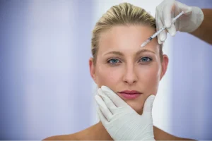 beautiful woman injecting forehead with botox filler