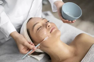 woman at a clinic getting chemical peel service from a clinician